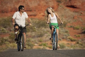 Flirting couple riding on bikes through red rock country